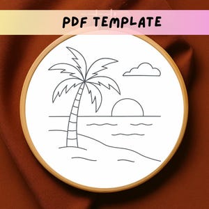 May include: A black and white line drawing of a palm tree on a beach with a sunset and a cloud in the sky. The drawing is in a round embroidery hoop.