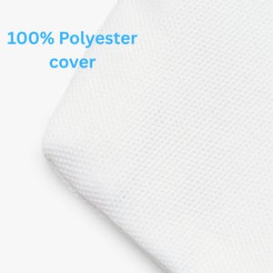 May include: Close-up of a white, textured fabric corner. The text "100% Polyester cover" is displayed in light blue, indicating the material composition of the item.