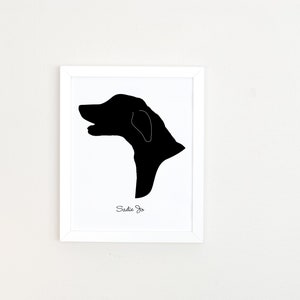 May include: A black and white silhouette of a dog's head in a white frame. The dog's name, "Sadie Jo", is written below the silhouette.