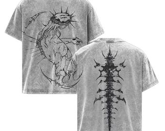 May include: Two gray t-shirts with black graphic designs. One shirt features a detailed illustration of a creature with a crown, the other a spine-like design. The shirts have a vintage, washed appearance.