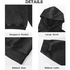 May include: Close-up details of a black hoodie. Features include a kangaroo pocket, large hood, ribbed hem, and ribbed cuffs. The word "DETAILS" is at the top of the image. The hoodie has a washed, vintage look.