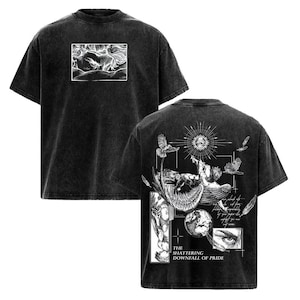 May include: Dark gray t-shirt with a distressed finish. The front features a white rectangular graphic of a creature. The back displays a detailed illustration with birds, an eye, and the text "THE SHATTERING DOWNFALL OF PRIDE."