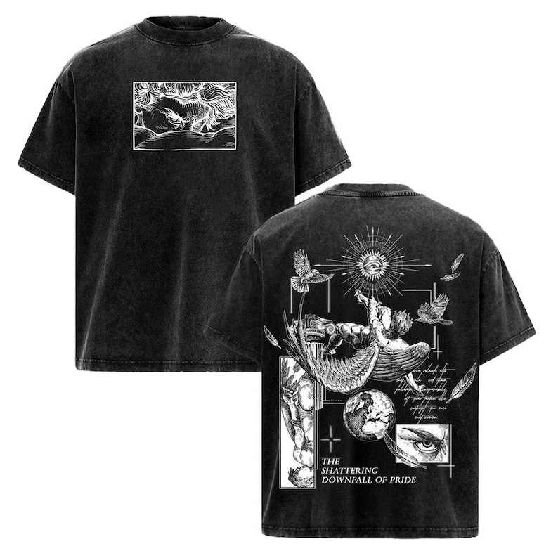 May include: Dark gray t-shirt with a distressed finish. The front features a white rectangular graphic of a creature. The back displays a detailed illustration with birds, an eye, and the text "THE SHATTERING DOWNFALL OF PRIDE."