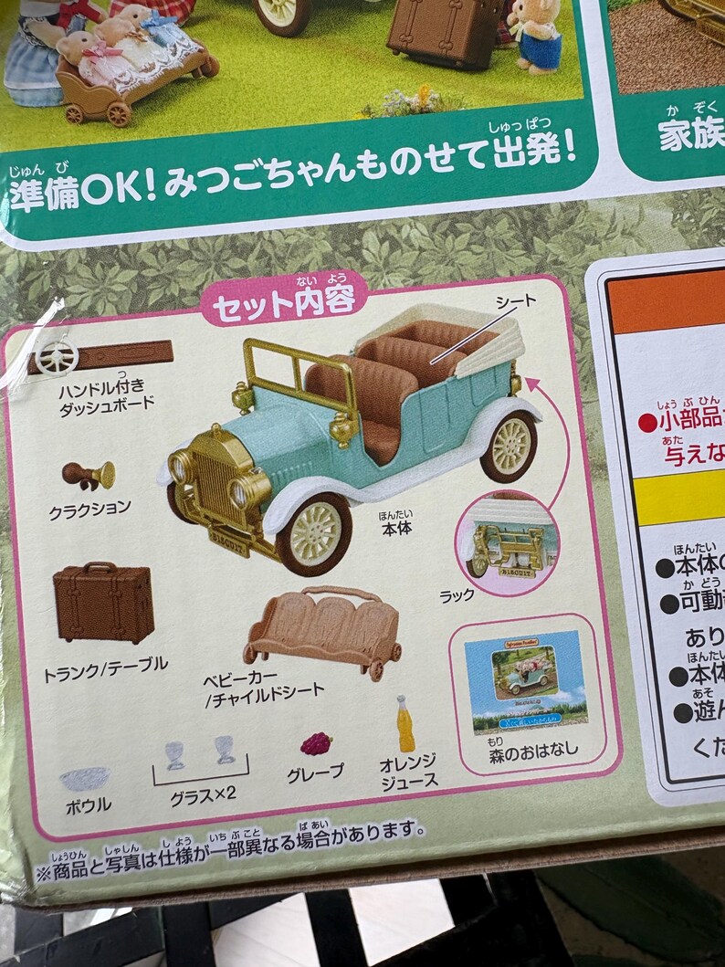 May include: A toy set featuring a light blue vintage car with brown seating, gold accents, and white wheels. The set includes a trunk, a baby carriage, a table, and other accessories. The packaging has Japanese text.