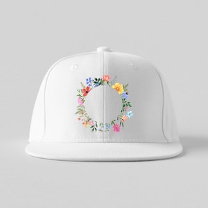 May include: A white baseball cap featuring a colorful floral wreath design. The wreath is composed of various flowers in shades of pink, yellow, blue, and green, arranged in a circular pattern around the cap's front.