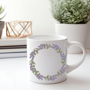 May include: White ceramic mug featuring a lavender wreath design. The wreath is composed of purple lavender flowers and green leaves, arranged in a circular pattern. The mug has a curved handle and is set against a bright background.
