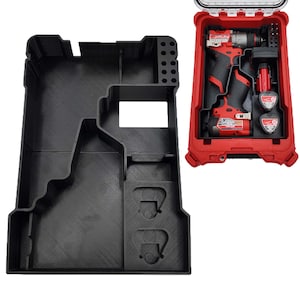 Puede incluir: Un organizador de herramientas de plástico negro con compartimentos moldeados a medida para un taladro, dos baterías y brocas. Junto a él, un maletín rígido rojo contiene un taladro rojo y negro, dos baterías y varias brocas.