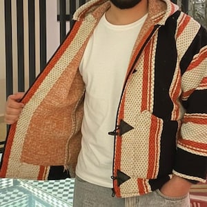 Könnte beinhalten: Eine weiße Keramik-Tasse mit schwarzem Henkel und dem Text "But First, Coffee" in fetter, schwarzer Schrift. Die Tasse steht auf einer Holzoberfläche. Die Tasse ist etwa 10 cm hoch.