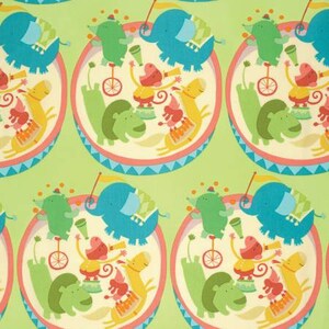 May include: A green background with a repeating pattern of colorful animals performing in a circus ring. The animals include elephants, hippos, monkeys, and a giraffe. The circus ring is decorated with a blue and white striped border.