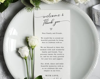 Op de afbeelding: Een witte rechthoekige trouwkaart met zwarte tekst die Welcome & Thank you, Dear Family and Friends leest, gevolgd door een dankbericht en de namen Jessica en Noah, geaccentueerd door een klein hartje en twee witte bloemen.