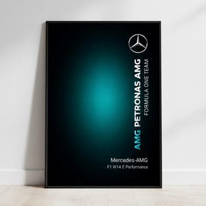 Puede incluir: Un póster enmarcado con fondo negro y degradado turquesa. El logotipo de Mercedes-AMG está en la esquina superior derecha, con el texto "AMG PETRONAS" y "FORMULA ONE TEAM" alineados verticalmente. Debajo, se lee "Mercedes-AMG F1 W14 E Performance."