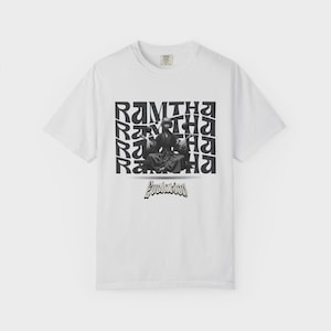 Puede incluir: Camiseta blanca con un gráfico en blanco y negro. El gráfico presenta la palabra "Ramtha" repetida en una fuente estilizada, con una imagen en blanco y negro de una persona en el centro. La palabra "Evolution" está debajo de la imagen.