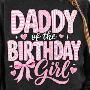 Könnte beinhalten: Ein schwarzes Sweatshirt mit Rundhalsausschnitt und dem rosa Schriftzug "DADDY of the BIRTHDAY Girl" in einer Mischung aus Streifen-, Punkt- und Blumenmustern. Das Design enthält kleine rosa Herzen, vierzackige Sterne und eine große rosa Schleife.