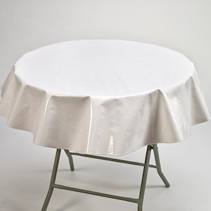 May include: White round tablecloth with a smooth, shiny finish. The tablecloth is draped over a round table with a white folding frame.