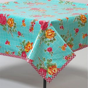 May include: A turquoise tablecloth with a red and white checkered border. The tablecloth features a floral pattern with pink, yellow, and green roses.