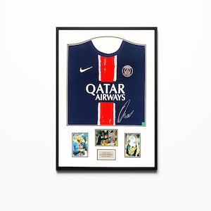 Pode incluir: Camisola de futebol do Paris Saint-Germain emoldurada em azul marinho com listras vermelhas e o logotipo da Qatar Airways. Inclui fotos pequenas e uma placa com texto. A camisola tem uma assinatura e o logotipo da Nike.