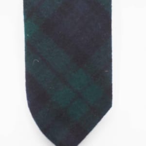 May include: A dark green and black patterned tie. The tie is made of a soft, textured fabric.