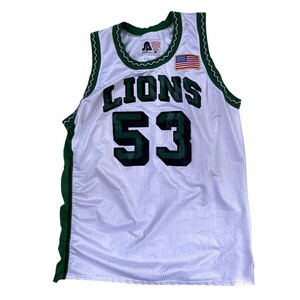 May include: White mesh jersey with green trim and the word "LIONS" in large, dark green letters. The number "53" is prominently displayed in dark green. An American flag patch is on the upper right chest.