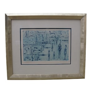 May include: A framed print featuring a blue ink illustration on a light blue background. The artwork displays a grid of abstract shapes and figures, including four standing human-like silhouettes. The piece is enclosed in a metallic silver frame.