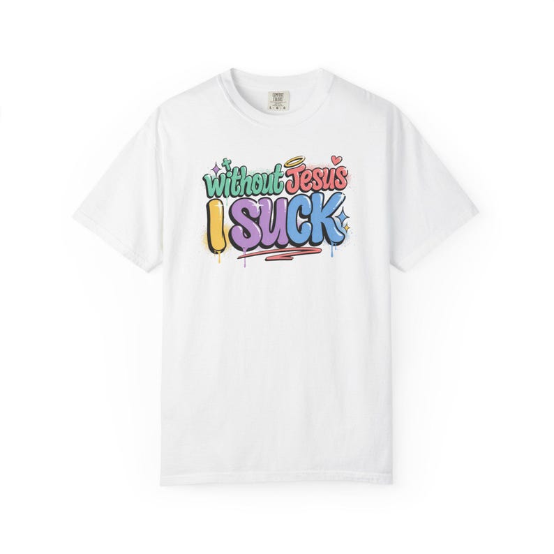 A white t-shirt with the colorful graffiti-style text "Without Jesus I Suck" is laid flat against a white background.