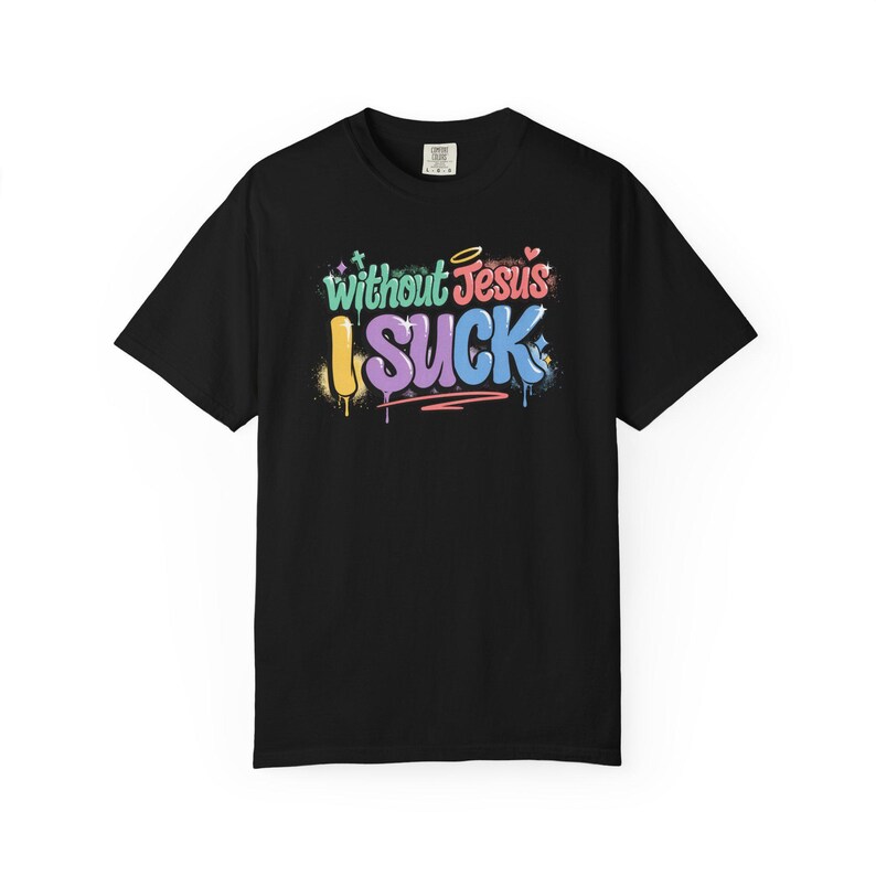 A black t-shirt with the phrase "Without Jesus I Suck" in colorful, graffiti-style text with paint drips and small hearts.