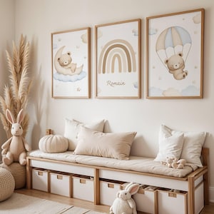 Peut inclure: Trois impressions d'art encadrées pour chambre d'enfant sur le thème des ours en peluche. L'une montre un ours sur une lune, une autre un arc-en-ciel et la troisième un ours avec un parachute. Les impressions sont dans des cadres en bois.