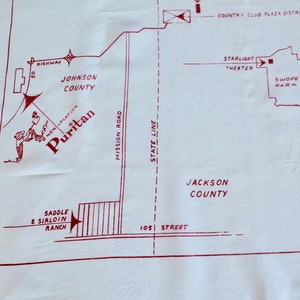 May include: A red and white map of a city with the words "Puritan", "Johnson County", "Jackson County", "Mission Road", "State Line", "105 Street", "Saddle & Sirloin Ranch", "Country Club Plaza District", "Starlight Theater", and "Swope Park".