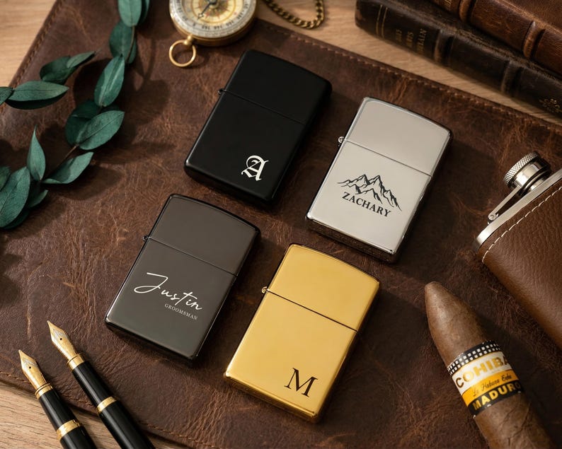 Puede incluir: Cuatro encendedores personalizados en negro, plateado y dorado, con grabados personalizados. Un encendedor negro presenta la letra "A", otro plateado tiene un dise&ntilde;o de monta&ntilde;a y el nombre "Zachary". Un tercer encendedor negro est&aacute; grabado con "Justin Groomman", y el &uacute;ltimo es dorado con la letra "M".