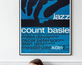 Könnte beinhalten: Gerahmtes Vintage-Jazz-Poster mit blauem Hintergrund und schwarzer Silhouette einer Hand, die Klavier spielt. Das Poster zeigt den Schriftzug "Jazz" und die Namen "Count Basie", "Miles Davis" und "Oscar Peterson".