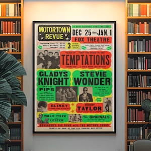Puede incluir: Un póster enmarcado de Motortown Revue vintage con The Temptations, Gladys Knight & The Pips y Stevie Wonder. El póster tiene un marco negro y se muestra contra una pared con estanterías a ambos lados. El texto del póster incluye el Fox Theatre y las fechas del espectáculo.