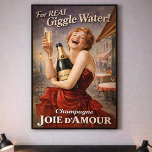 Op de afbeelding: Een ingelijste vintage poster met een vrouw in een rode jurk die een champagnefles en een glas vasthoudt. De tekst op de poster luidt "For Real Giggle Water!" en "Champagne JOIE D'AMOUR."