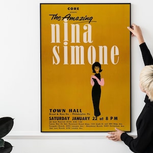 Könnte beinhalten: Ein Vintage-Poster für ein Nina Simone Konzert. Das Poster hat einen senfgelben Hintergrund mit den Worten "The Amazing Nina Simone" in großen weißen Buchstaben. Eine stilisierte Illustration von Nina Simone in einem schwarzen Kleid ist ebenfalls vorhanden.
