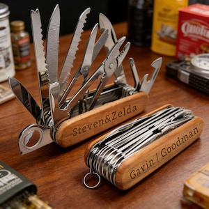May include: Two personalized multi-tools with wooden handles and stainless steel tools. One is open, displaying various blades, saws, and pliers. The other is closed. The text "Steven & Zelda" and "Gavin | Goodman" are engraved on the handles.