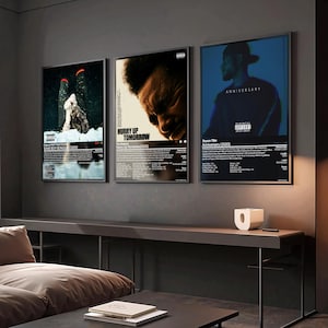 May include: Three framed music album art posters. The posters feature album covers with text and images. One poster says "SOME SEXY SONGS (2023)". Another says "HURRY UP TOMORROW". The third says "ANNIVERSARY (2020)".