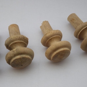 May include: Four wooden finials with a rounded top and a fluted design. The finials are light brown in color and have a smooth finish.