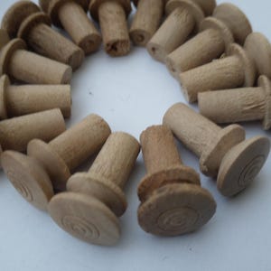 May include: A close-up of a group of wooden knobs with a circular top and a cylindrical base. The knobs are arranged in a circle, with the tops facing outwards.