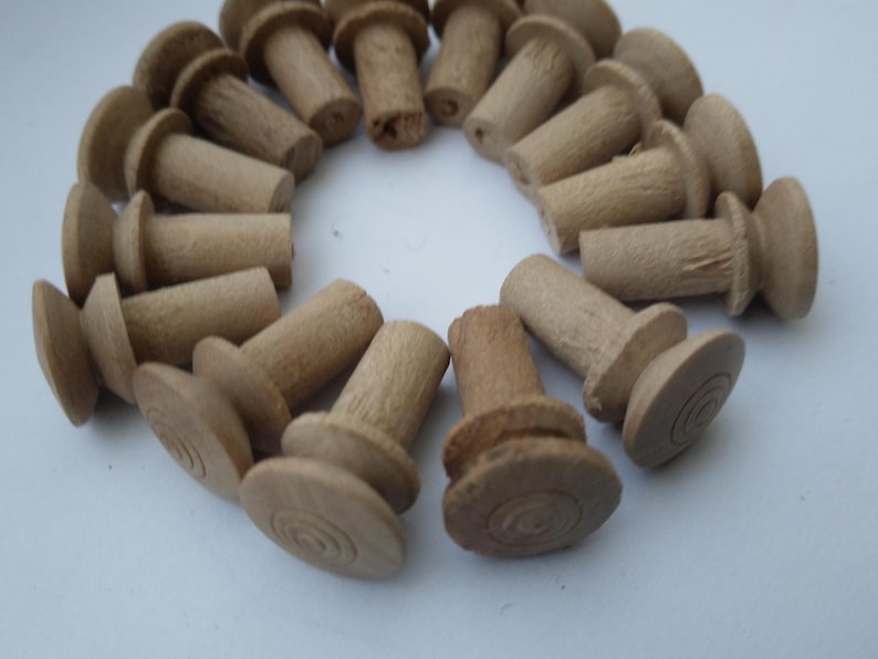 May include: A close-up of a group of wooden knobs with a circular top and a cylindrical base. The knobs are arranged in a circle, with the tops facing outwards.