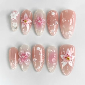 Unghie finte a pressione con fiori, nail art floreale 3D, unghie rosa tenue, unghie da sposa eleganti, unghie con motivo a giglio fatte a mano