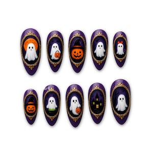 Pode incluir: Um conjunto de dez unhas postiças em formato amêndoa com base roxa, cada uma com uma moldura oval dourada. Os designs incluem fantasmas brancos, abóboras de Halloween, uma casa assombrada e um fantasma com um laço vermelho.