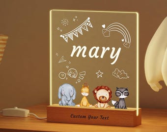 May include: A personalized night light with the name "mary" etched on a clear acrylic panel. The panel features cartoon animal illustrations and decorative elements. The base is made of wood, with the text "Custom Your Text" engraved.
