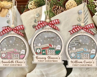 May include: Three personalized Christmas ornaments with a snow globe design. Each ornament has a wooden frame, a red and white checkered bow, and the year 2024. The ornaments are personalized with names and dates.