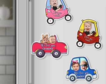 May include: Set of four car-shaped magnets with photos of babies. The cars are pink, red, and blue, with black wheels. Text includes "I love you Mommy," "We love you Grandma," and "I love you Daddy."