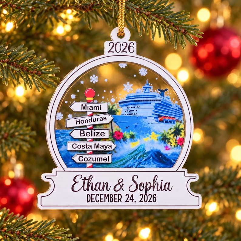 K&ouml;nnte beinhalten: Ein wei&szlig;er, kugelf&ouml;rmiger Weihnachtsbaumschmuck mit einem Kreuzfahrtschiff, tropischen Pflanzen und einem Wegweiser mit der Aufschrift Miami, Honduras, Belize, Costa Maya und Cozumel. Der Schmuck zeigt die Namen Ethan & Sophia und 24. Dezember 2026.