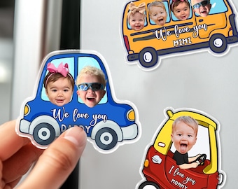 May include: A hand holding a blue car-shaped magnet with two children's faces and the text "We love you Daddy." Other magnets include a yellow school bus with children's faces and the text "We love you Mimi," and a red car with a child's face and the text "I love you Mommy."
