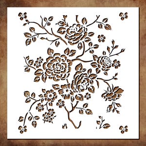 May include: A square stencil featuring a detailed floral pattern with multiple roses, buds, and leaves. The design is cut out from a white sheet, revealing a brown background through the negative space of the intricate botanical illustration.