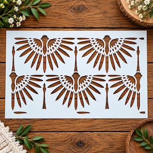 May include: A rectangular white stencil featuring a repeating pattern of stylized birds with large, spread wings. The design consists of four bird silhouettes arranged in a grid, each with detailed, geometric feather cutouts across their wings.