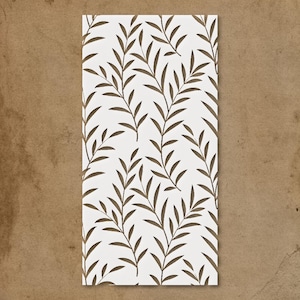 May include: A rectangular white surface with a repeating pattern of brown, stylized leaves and branches. The leaves are long and slender, arranged in vertical rows. The background is a textured, brown surface.
