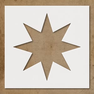 May include: A white, eight-pointed star stencil on a square white background. The star shape is cut out, revealing a brown surface. The stencil is likely used for painting or crafting projects.