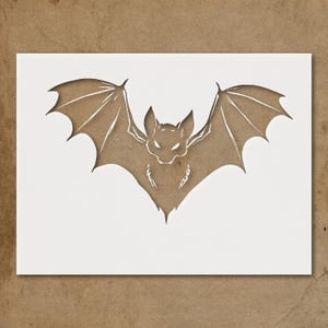May include: A paper cutout of a bat with outstretched wings. The bat is brown, with white highlights, and is set against a white background. The bat's wings are detailed with lines, and the eyes are glowing.