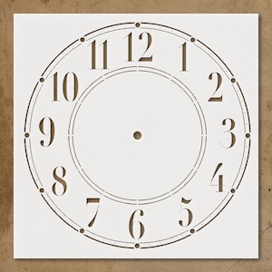 May include: A clock face stencil with brown numerals and markings on a white background. The numbers 1 through 12 are displayed in a classic font. The stencil is designed for crafting and DIY projects.